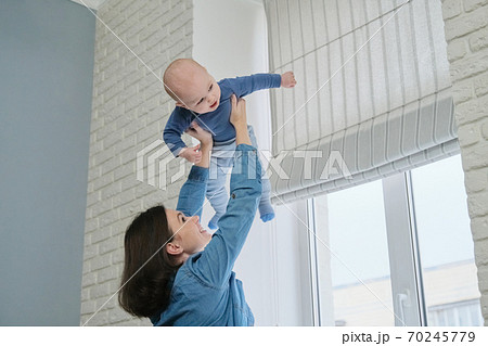 Happy young beautiful mother playing with toddler son Happy young beautiful mother playing with toddler son 70245779