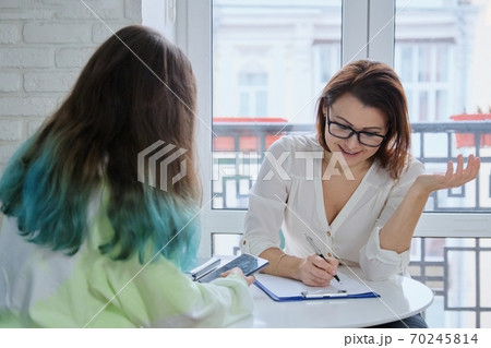 Female psychologist talking with teenage girl 15, 16 years old Female psychologist talking with teenage girl 15, 16 years old 70245814