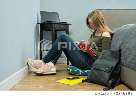 Young woman university student with textbooks studying at home 70246395