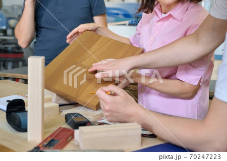 Close-up work in carpentry furniture workshop, hands of workers with wood samples 70247223