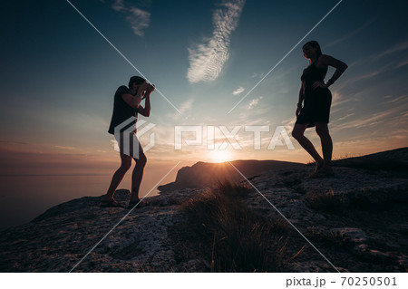Cheese. Concentrated man taking photo of his girlfriend during picnic. 70250501