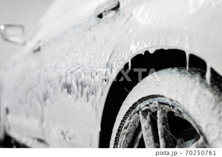 Car washing process. Foaming detergent covers side of the car, clean it from dirt and dust. Car washing process. Foaming detergent covers side of the car, clean it from dirt and dust. 70250761