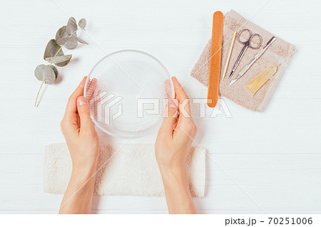 Flat lay composition female hands holding bowl of soapy water 70251006