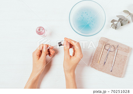 Home manicure process, female hands apply cuticle oil Home manicure process, female hands apply cuticle oil 70251028
