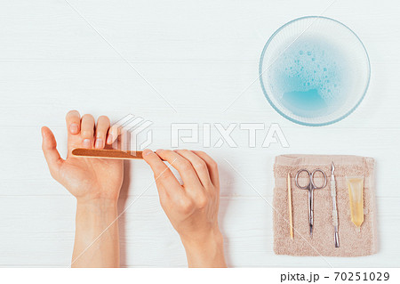 Female hands doing manicure at home using nail file Female hands doing manicure at home using nail file 70251029