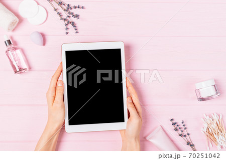 Flat lay female hands hold electronic tablet with blank screen 70251042