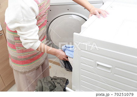 衣類をドラム式洗濯機に入れる主婦 衣類をドラム式洗濯機に入れる主婦 70251079