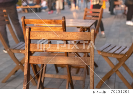 back of wooden chair close up and table with chairs stands on street in city cafe back of wooden chair close up and table with chairs stands on street in city cafe 70251202