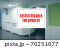 Sign on the door of a hospital corridor indicating an access area reserved for patients with covid-19 70251677