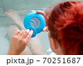 Woman in a hot tub bath checking the level of cleaning products 70251687