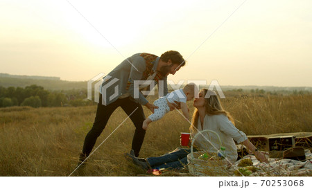 Happy family having fun during evening picnic 70253068
