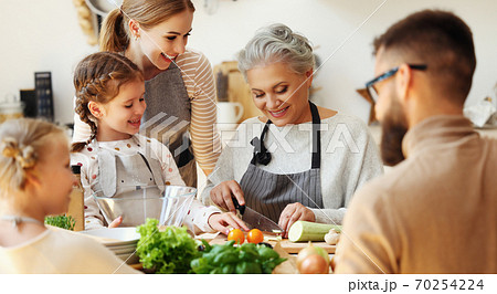 Happy family preparing healthy food in home kitchen. Happy family preparing healthy food in home kitchen. 70254224