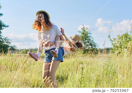 Happy children two girls sisters laughing and having fun in meadow Happy children two girls sisters laughing and having fun in meadow 70255067