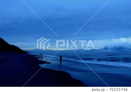 夜明け前の海辺の釣り人 70255746