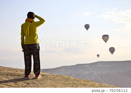The girl looks at the flight of balloons in Cappadocia. Turkey 70256112