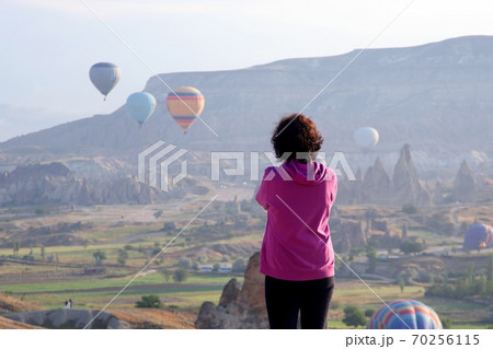 The girl looks at the flight of balloons in Cappadocia. Turkey 70256115