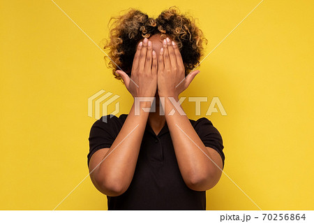 Young african woman covering face with hands hiding her emotions from everybody. Young african woman covering face with hands hiding her emotions from everybody. 70256864