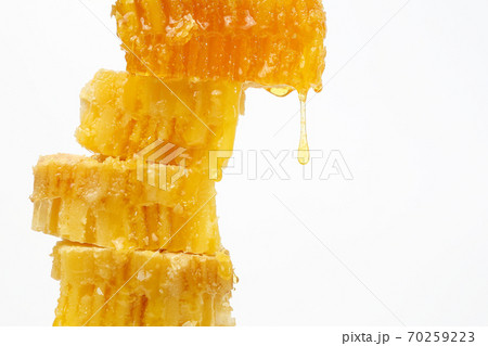 honey flowing from the honeycombs on a light background honey flowing from the honeycombs on a light background 70259223