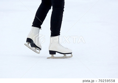 the legs of a man rolling on skates on the ice rink the legs of a man rolling on skates on the ice rink 70259558