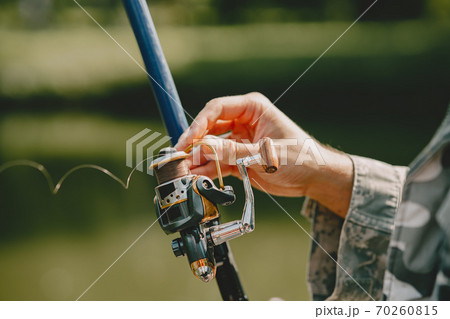 Man fishing and holds the angling rod Man fishing and holds the angling rod 70260815