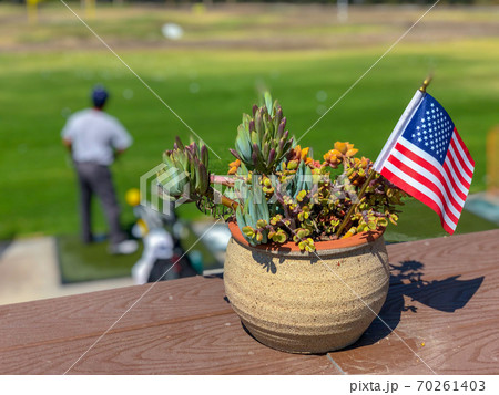 Patriotic flower pot with American flags and golfer on the background. 70261403