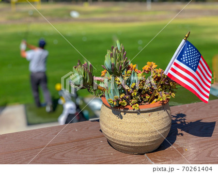 Patriotic flower pot with American flags and golfer on the background. Patriotic flower pot with American flags and golfer on the background. 70261404
