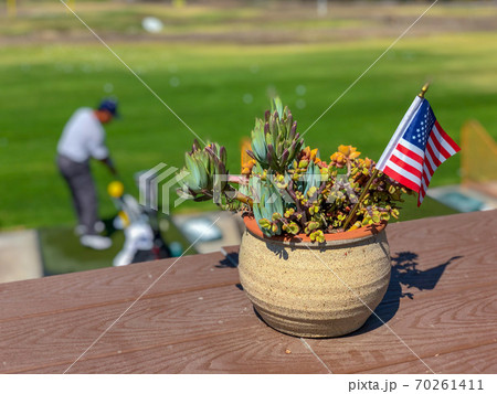 Patriotic flower pot with American flags and golfer on the background. 70261411