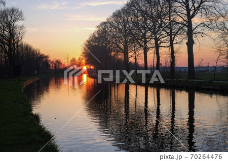 Panorama of a gorgeous scenic sunset at a river or canal Panorama of a gorgeous scenic sunset at a river or canal 70264476
