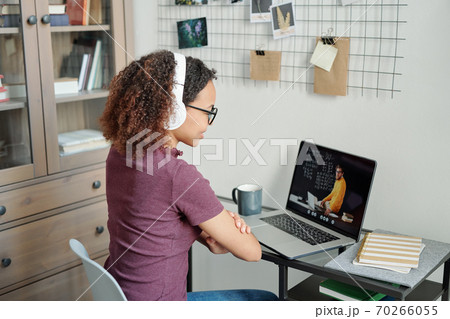 Young mixed-race diligent student having online lesson in home environment Young mixed-race diligent student having online lesson in home environment 70266055