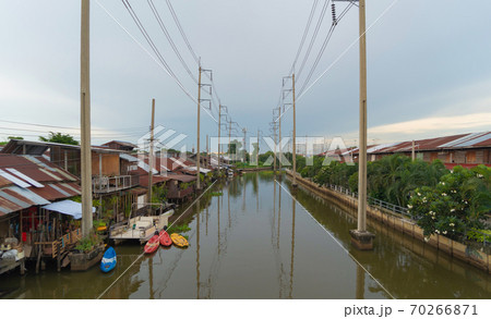 Utility poles tower and cable wires and Chao Phraya River with reflection of lake at sunset in Bangkok, Thailand in energy electric technology and industry concept. 70266871