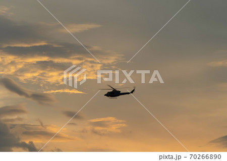 Close up of transport helicopter or military aircraft flying isolated on sunset sky 70266890