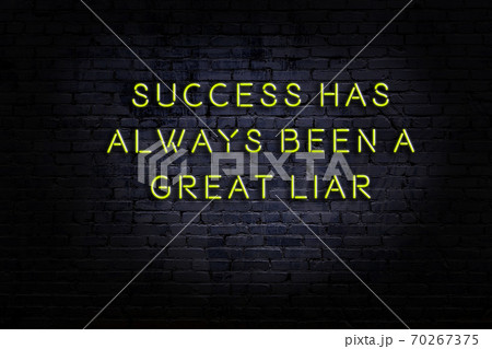 Wise quote. Neon inscription against brick wall Wise quote. Neon inscription against brick wall 70267375