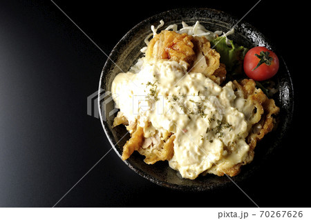 ミニトマトなど野菜も一緒に乗っているタルタルソースたっぷりのチキン南蛮丼(黒背景、俯瞰) ミニトマトなど野菜も一緒に乗っているタルタルソースたっぷりのチキン南蛮丼(黒背景、俯瞰) 70267626
