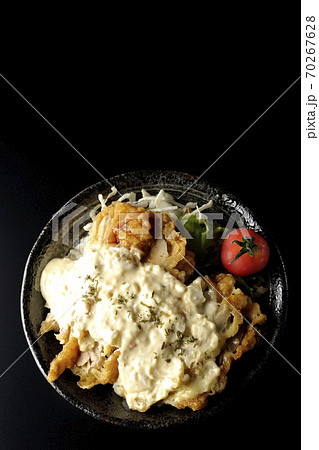 ミニトマトなど野菜も一緒に乗っているタルタルソースたっぷりのチキン南蛮丼(黒背景、俯瞰) ミニトマトなど野菜も一緒に乗っているタルタルソースたっぷりのチキン南蛮丼(黒背景、俯瞰) 70267628