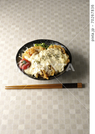 ミニトマトなど野菜も一緒に乗っているタルタルソースたっぷりのチキン南蛮丼とお箸 70267836