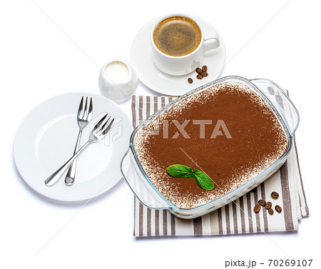 Traditional Italian Tiramisu dessert in glass baking dish and cup of fresh espresso coffee isolated on white background with clipping path Traditional Italian Tiramisu dessert in glass baking dish and cup of fresh espresso coffee isolated on white background with clipping path 70269107