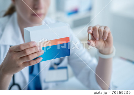 Woman in a lab coat presenting new medicine 70269239