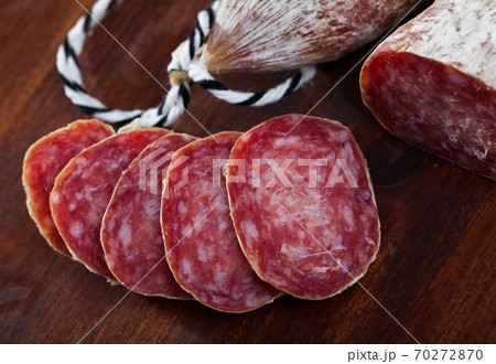 Spanish longaniza salami sausages cut in slices on a woodefn desk 70272870