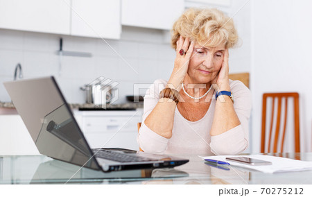 Elderly woman using laptop 70275212
