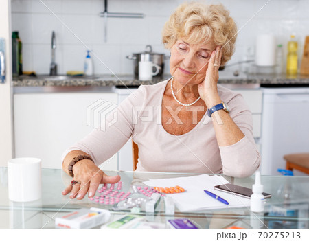 Confused woman among a lot of medicines Confused woman among a lot of medicines 70275213