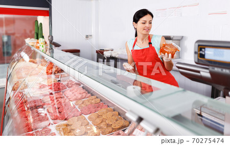 woman seller showing different sausages woman seller showing different sausages 70275474