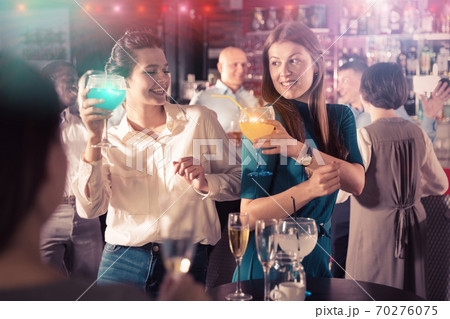 Two young women drinking cocktails Two young women drinking cocktails 70276075