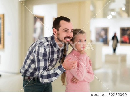 Father and daughter looking at paintings in halls of museum Father and daughter looking at paintings in halls of museum 70276090