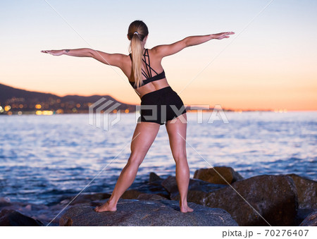 Adult woman is practicing stretching Adult woman is practicing stretching 70276407
