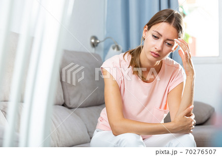 Sick female holding hands on her head Sick female holding hands on her head 70276507