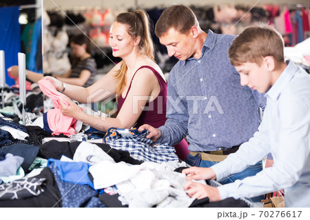 family are reviewing models of clothes 70276617
