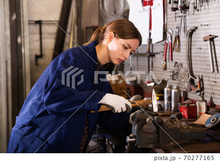 Young woman handles part on bench vise Young woman handles part on bench vise 70277165