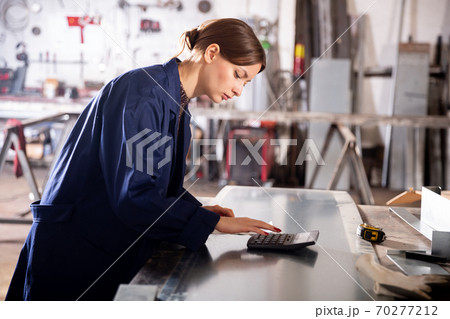 Young woman engineer calculation of material costs 70277212