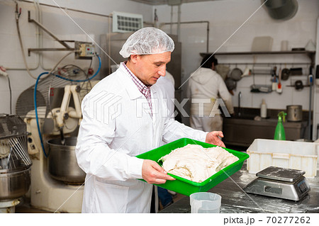 Bakers weigh the dough on the scales Bakers weigh the dough on the scales 70277262