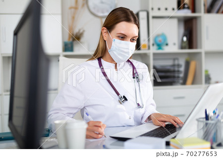 Female doctor in lab coat and protective medical masks Female doctor in lab coat and protective medical masks 70277653